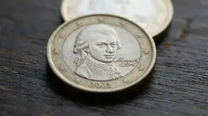 Moneta da 1 euro del 2002 con ritratto inciso, su sfondo in legno scuro