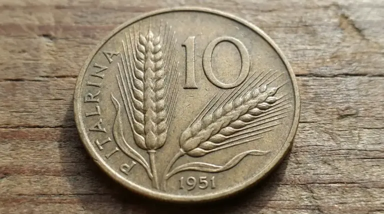 Moneta da 10 lire del 1951 con spighe di grano su sfondo in legno