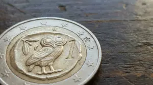 Moneta da 1 euro greca con simbolo del gufo su sfondo in legno