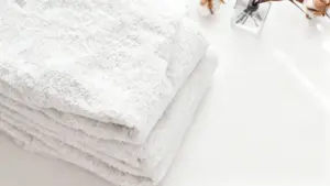 Pile di asciugamani bianchi piegati su una superficie chiara