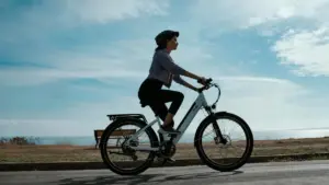 Persona che pedala una bici elettrica all'aperto vicino al mare in una giornata soleggiata