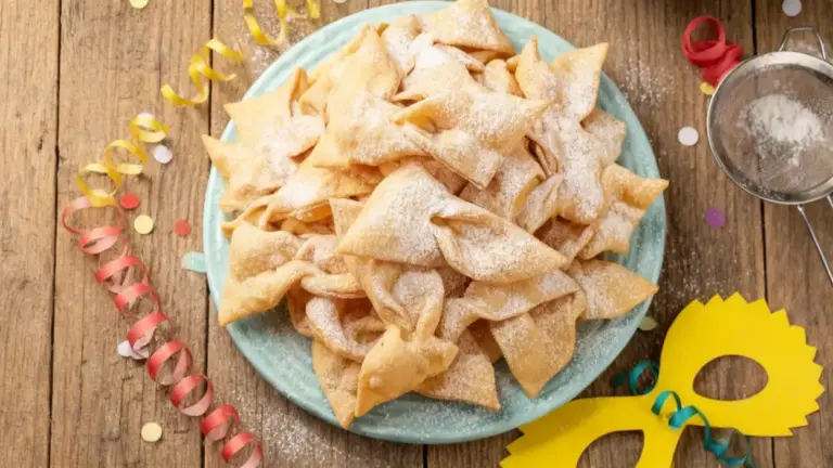 Vassoio di chiacchiere croccanti spolverate di zucchero a velo su tavolo in legno