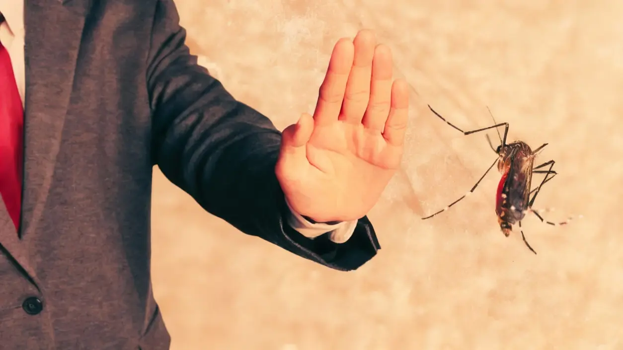 Persona con la mano alzata per respingere una zanzara in primo piano