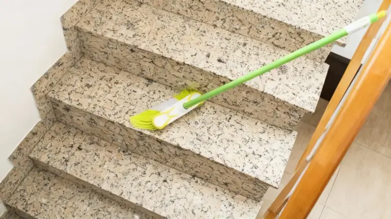 Scopa su scale condominiali di marmo durante la pulizia