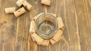 Barattolo di vetro circondato da tappi di sughero su un tavolo in legno