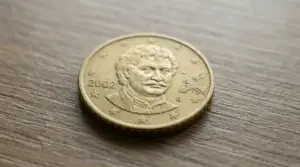 Moneta da 50 centesimi greca del 2002 con lettera S su sfondo di legno