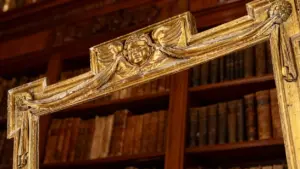 Dettaglio di una cornice antica in legno intagliato e dorato con motivi decorativi