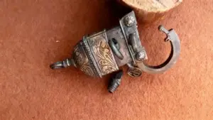 Vecchia chiave in ferro decorata con incisioni ornamentali su fondo marrone