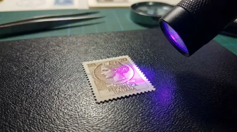 Francobollo da 20 lire Siracusana illuminato da luce UV su sfondo scuro