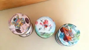 Tre vecchi giocattoli in latta con illustrazioni colorate sul coperchio