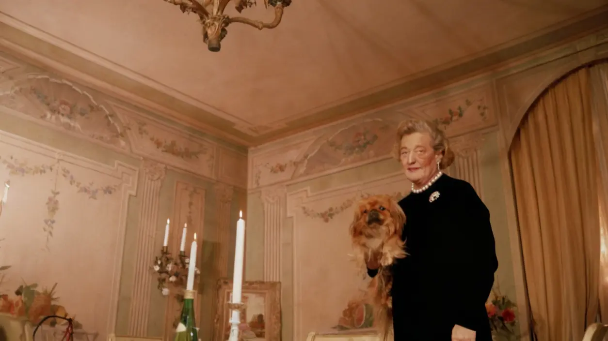 Una persona anziana in un elegante salotto con una lampada a soffitto in vetro soffiato