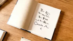 Libro aperto con dedica autografata su un tavolo in legno