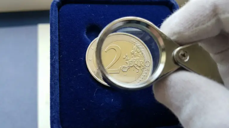 Primo piano di una moneta da 2 euro osservata con lente d'ingrandimento