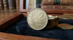 Moneta da 2 lire del 1958 con ramo d'ulivo, esposta in una teca