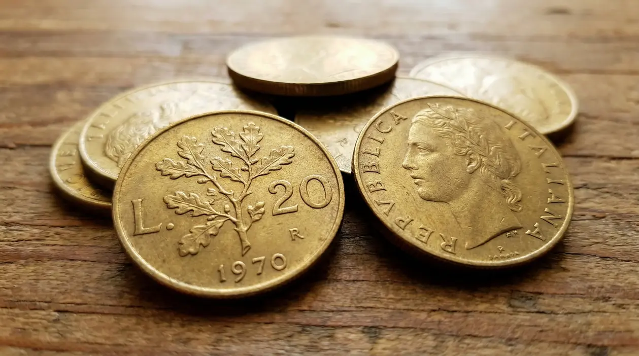 Monete italiane da 20 lire del 1970 su una superficie in legno