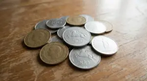 Vecchie monete italiane in lire sparse su un tavolo in legno