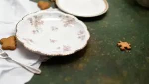 Vecchio piatto in porcellana decorato a mano con motivi floreali su tavolo verde