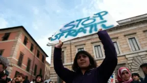 Donna solleva un cartello durante una manifestazione contro gli sfratti in una città italiana