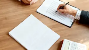 Due persone al tavolo esaminano documenti e utilizzano una calcolatrice