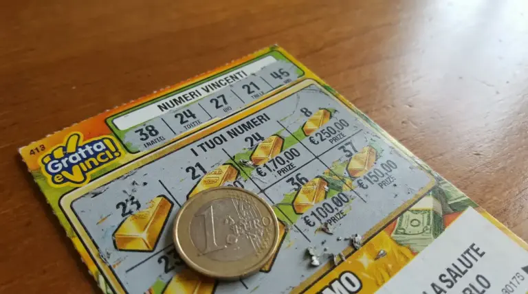 Biglietto Gratta e Vinci parzialmente grattato con una moneta da un euro sopra