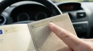 Mano che indica un simbolo su un libretto di circolazione all'interno di un'auto