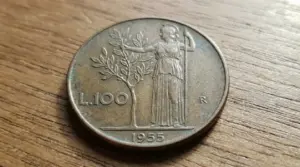 Moneta da 100 lire del 1955 su superficie di legno