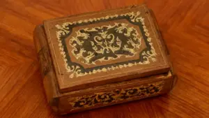 Portagioie in legno antico con intagli decorativi su un tavolo