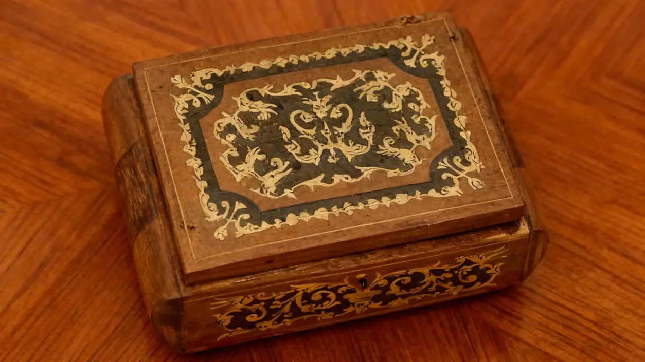 Portagioie in legno antico con intagli decorativi su un tavolo