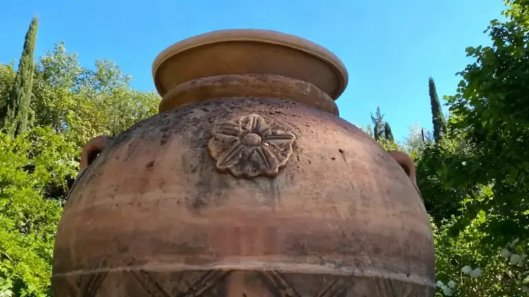 Grande vaso in terracotta con decorazioni floreali in un giardino soleggiato