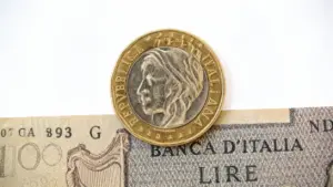 Una moneta da 500 lire sopra una vecchia banconota italiana da 100 lire