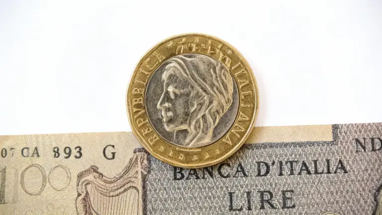 Una moneta da 500 lire sopra una vecchia banconota italiana da 100 lire