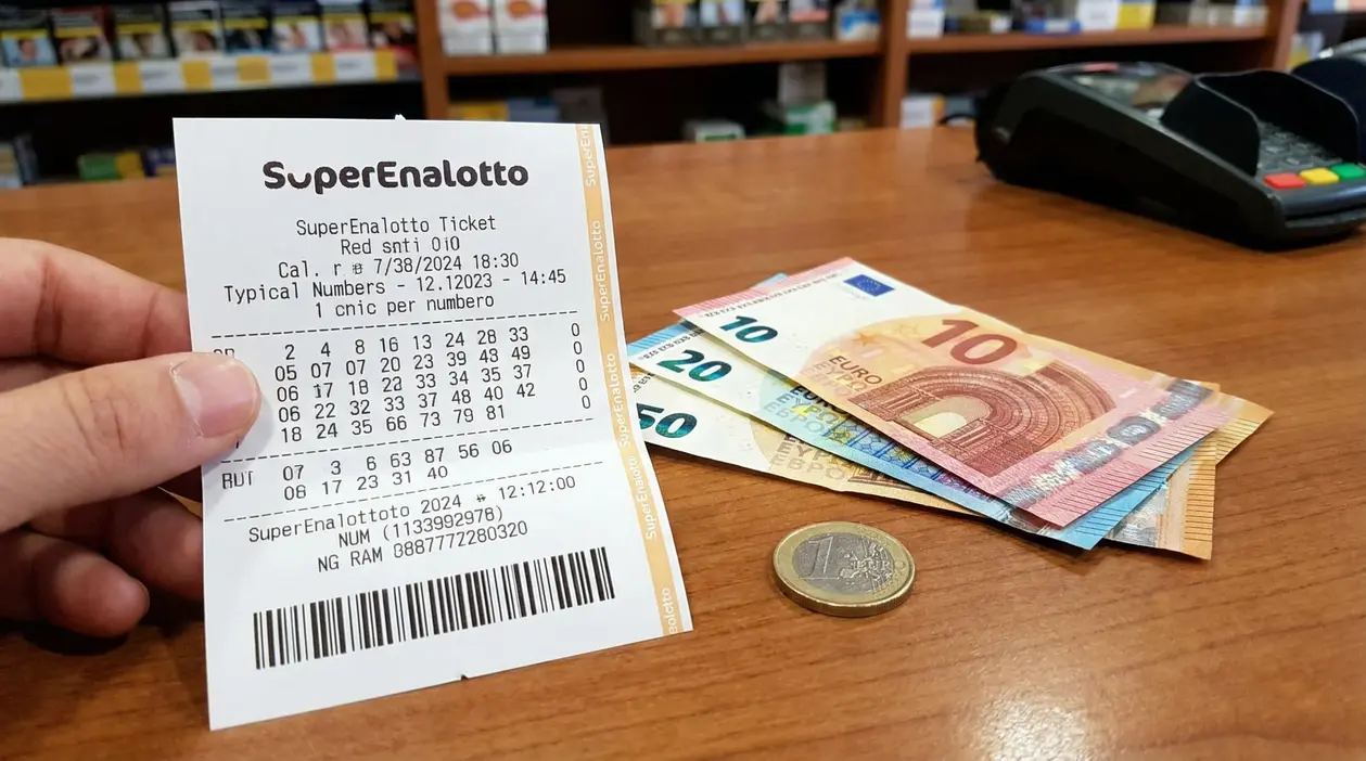 Biglietto del Superenalotto accanto a banconote e moneta da un euro su un bancone